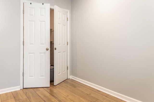 unfurnished bedroom with light wood-style flooring and baseboards