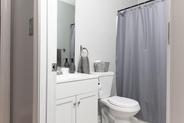 full bath with a shower with shower curtain, vanity, and toilet