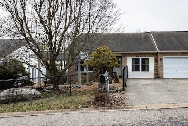 view of front facade with driveway, a fenced front yard, and brick siding