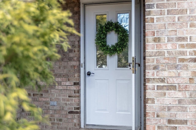 view of exterior entry with brick siding