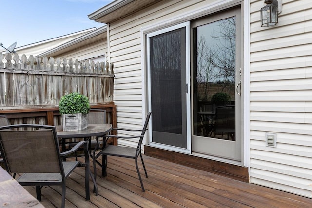 deck with outdoor dining area and fence