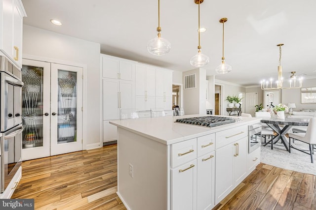 11304 Chivalry Chase Ln, Spotsylvania, VA 22551 - kitchen featuring appliances with stainless steel finishes, light wood-style flooring, open floor plan, white cabinets, and recessed lighting