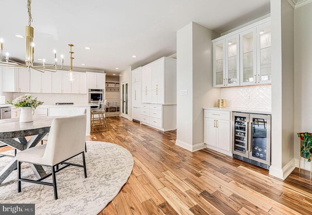 11304 Chivalry Chase Ln, Spotsylvania, VA 22551 - dining room with wine cooler, a chandelier, recessed lighting, a dry bar, and baseboards