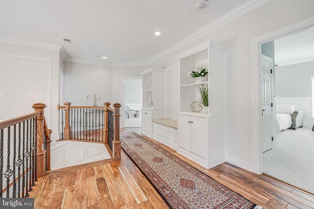 11304 Chivalry Chase Ln, Spotsylvania, VA 22551 - corridor with an upstairs landing, light wood-style floors, crown molding, recessed lighting, and a decorative wall
