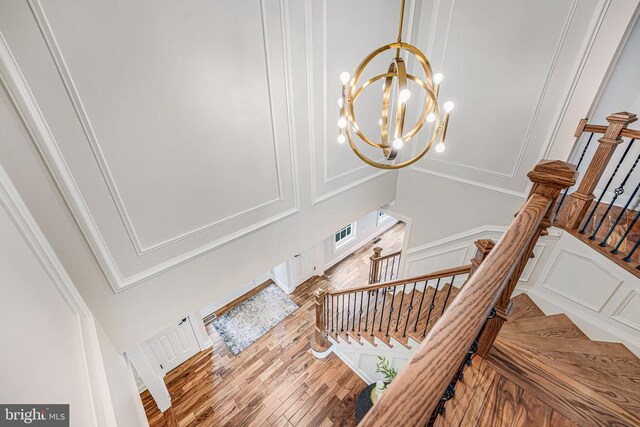 11304 Chivalry Chase Ln, Spotsylvania, VA 22551 - stairway featuring a decorative wall, a chandelier, and wood finished floors