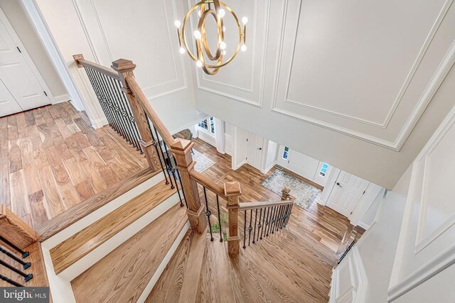 11304 Chivalry Chase Ln, Spotsylvania, VA 22551 - stairs featuring wood finished floors, a chandelier, and a decorative wall