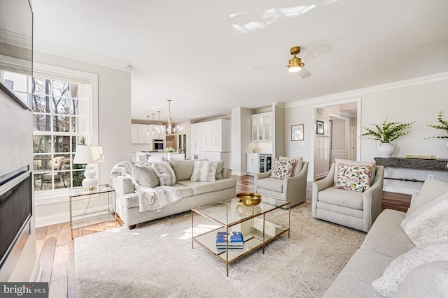 11304 Chivalry Chase Ln, Spotsylvania, VA 22551 - living area with crown molding, light wood finished floors, a chandelier, baseboards, and a ceiling fan