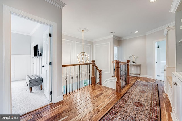 11304 Chivalry Chase Ln, Spotsylvania, VA 22551 - hallway with wood finished floors, an upstairs landing, a chandelier, a decorative wall, and recessed lighting