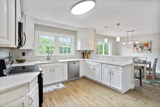 210 Jackson Ave, New Market, VA 22844 - kitchen with stainless steel appliances, a sink, light wood-style flooring, a peninsula, and white cabinets