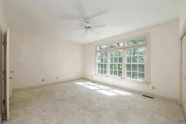 carpeted empty room with a ceiling fan and baseboards