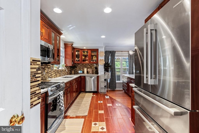 3227 Lancaster Ring Rd, Fredericksburg, VA 22408 - kitchen featuring appliances with stainless steel finishes, a sink, decorative backsplash, glass insert cabinets, and recessed lighting