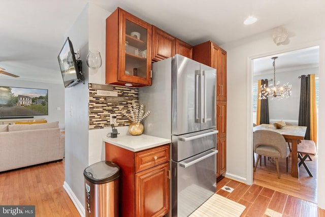 3227 Lancaster Ring Rd, Fredericksburg, VA 22408 - kitchen with freestanding refrigerator, light wood-style flooring, tasteful backsplash, crown molding, and glass insert cabinets