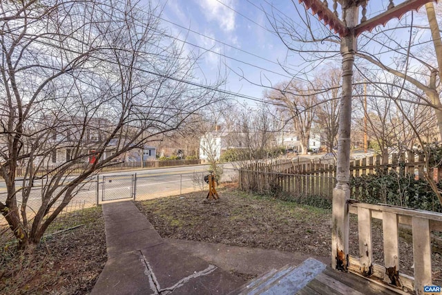 view of yard with a gate, fence, and a residential view
