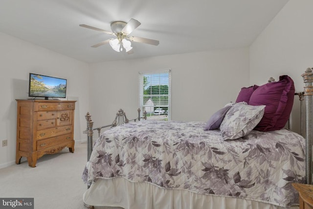 bedroom with light colored carpet, ceiling fan, and baseboards