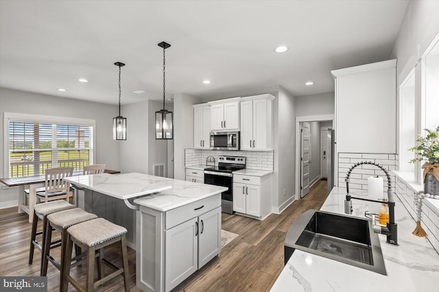 15411 Cedar Hill Dr, Mineral, VA 23117 - kitchen with stainless steel appliances, backsplash, a center island, a kitchen bar, and white cabinets