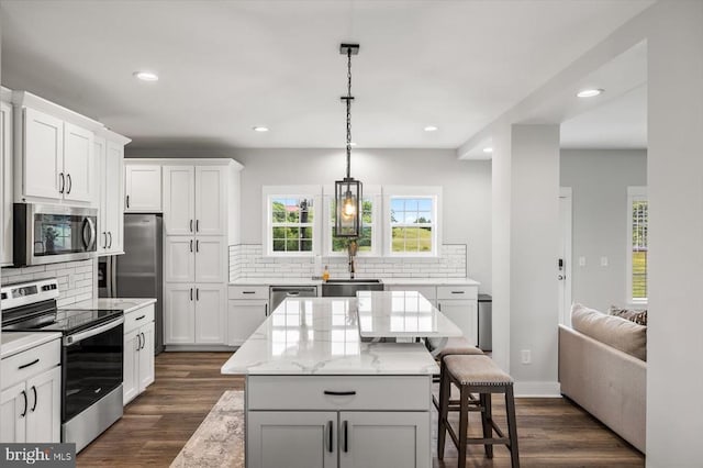 15411 Cedar Hill Dr, Mineral, VA 23117 - kitchen with appliances with stainless steel finishes, a breakfast bar, backsplash, a center island, and recessed lighting