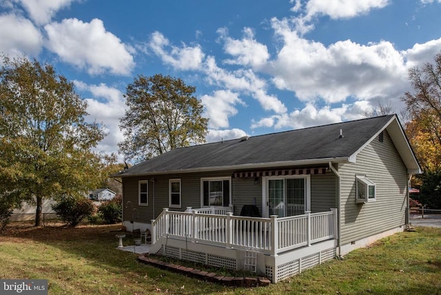 rear view of property with a wooden deck, a lawn, and crawl space