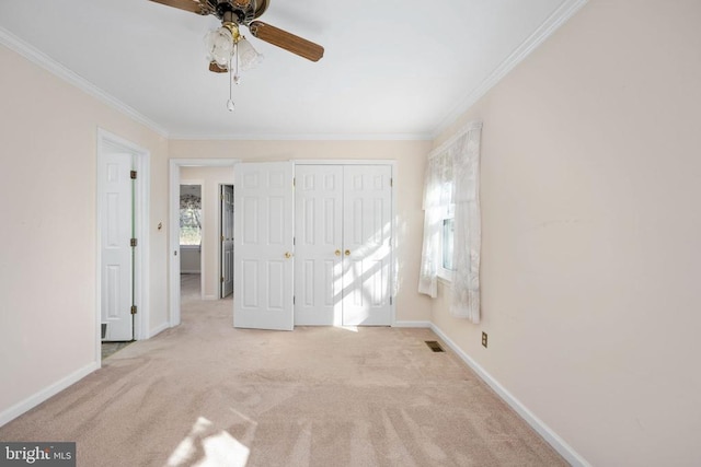 unfurnished bedroom with visible vents, baseboards, carpet floors, a closet, and crown molding