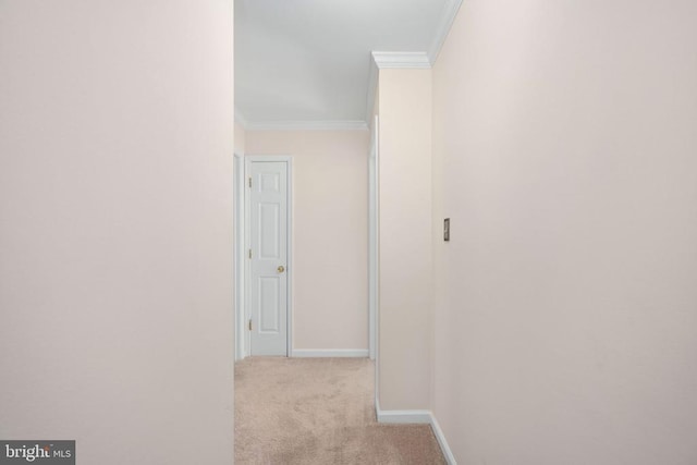 hallway with light carpet, crown molding, and baseboards