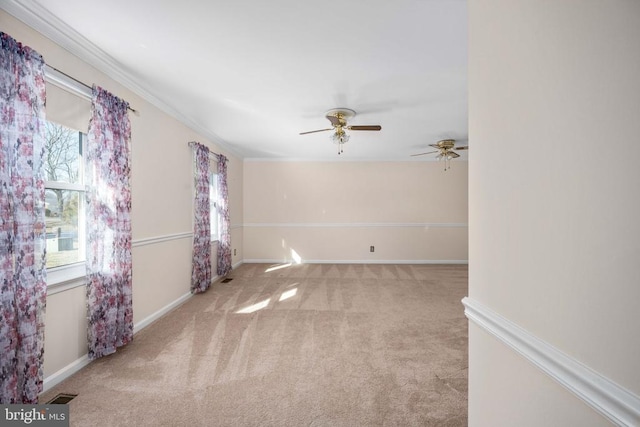 empty room featuring visible vents, crown molding, baseboards, ceiling fan, and light colored carpet