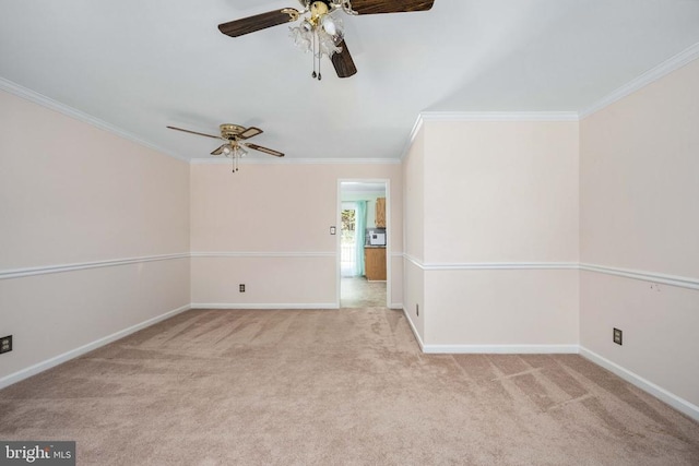 spare room featuring ceiling fan, crown molding, baseboards, and carpet floors