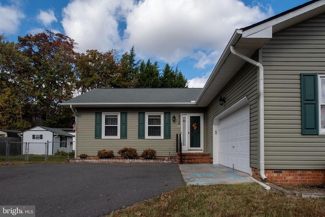 view of front of property featuring aphalt driveway, an attached garage, and fence