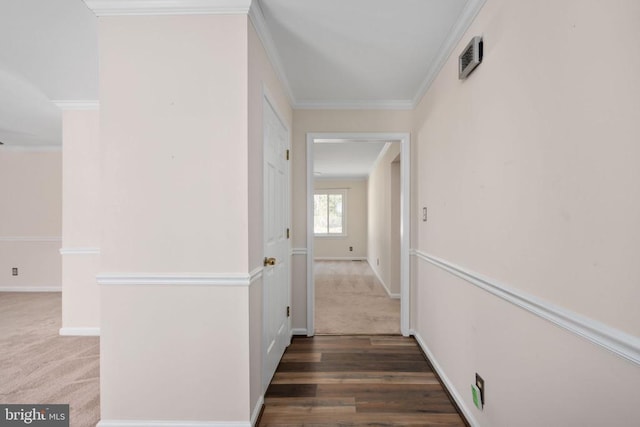 corridor featuring wood finished floors, baseboards, carpet, and ornamental molding