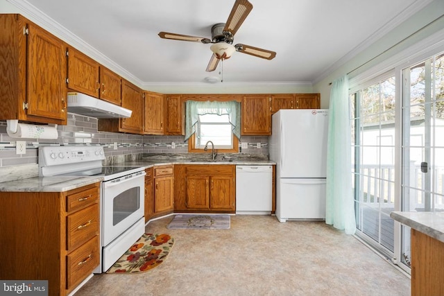 kitchen featuring white appliances, crown molding, brown cabinets, and under cabinet range hood