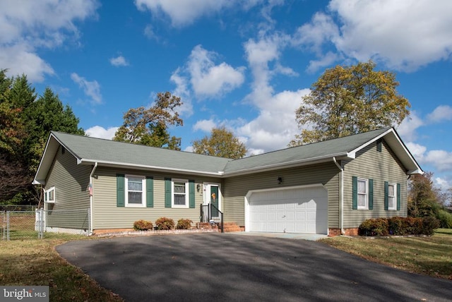 ranch-style home with driveway, an attached garage, and fence