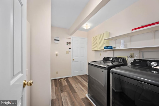 washroom featuring washer and clothes dryer, laundry area, baseboards, and wood finished floors