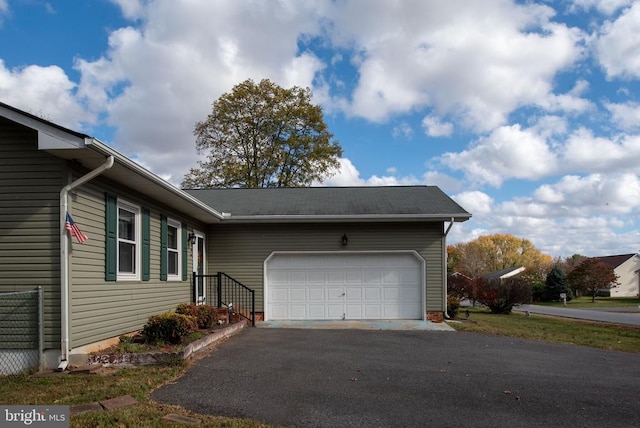 view of home's exterior with aphalt driveway and an attached garage