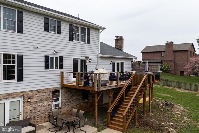 back of property featuring a deck, a chimney, a patio area, stairs, and a shingled roof