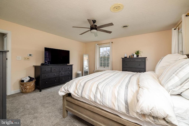 carpeted bedroom featuring ceiling fan and a textured ceiling