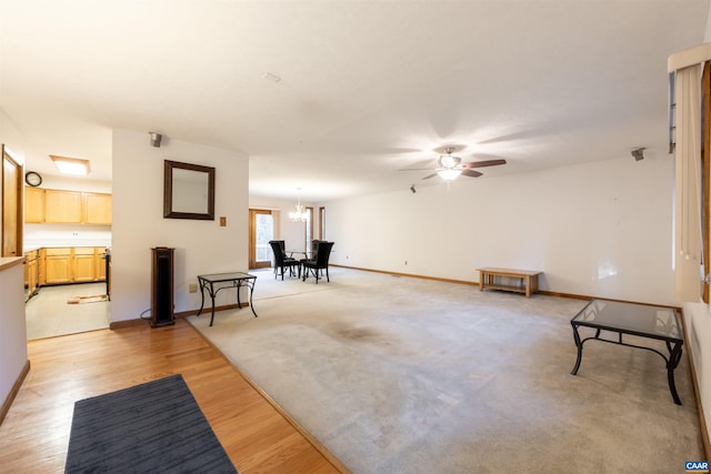 210 Pasture Ln, Stanardsville, VA 22973 - unfurnished living room with baseboards, light wood-style flooring, and ceiling fan with notable chandelier