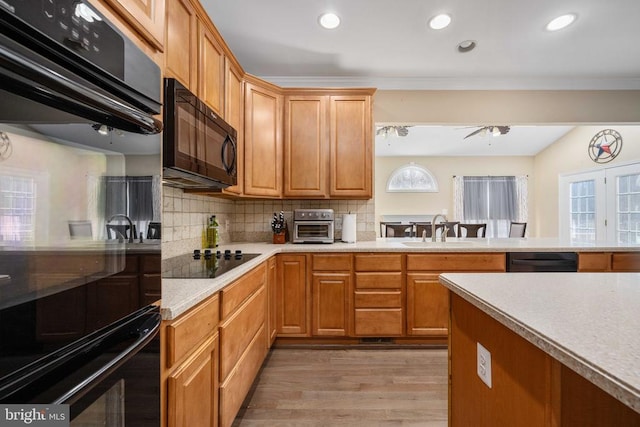 5819 Telluride Ln, Spotsylvania, VA 22553 - kitchen featuring black appliances, a sink, light countertops, tasteful backsplash, and light wood-style floors