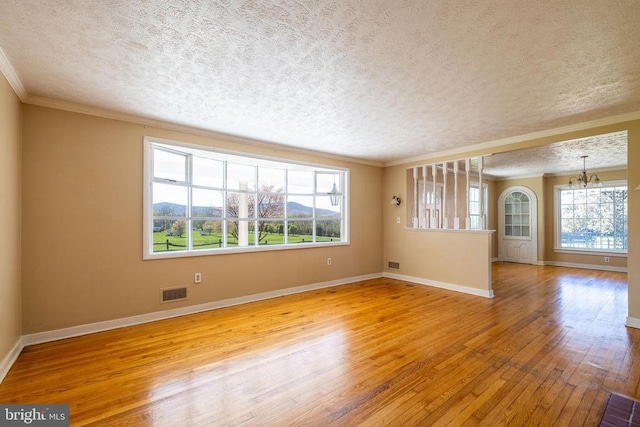 407 Kite Hollow Rd, Stanley, VA 22851 - empty room featuring a chandelier, hardwood / wood-style floors, ornamental molding, plenty of natural light, and a textured ceiling