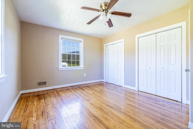 407 Kite Hollow Rd, Stanley, VA 22851 - unfurnished bedroom with light wood-style flooring, two closets, baseboards, and ceiling fan