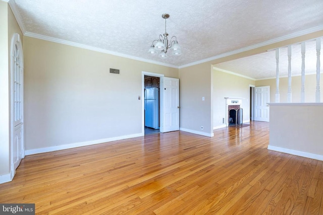 407 Kite Hollow Rd, Stanley, VA 22851 - empty room featuring a chandelier, light wood-type flooring, baseboards, crown molding, and a fireplace