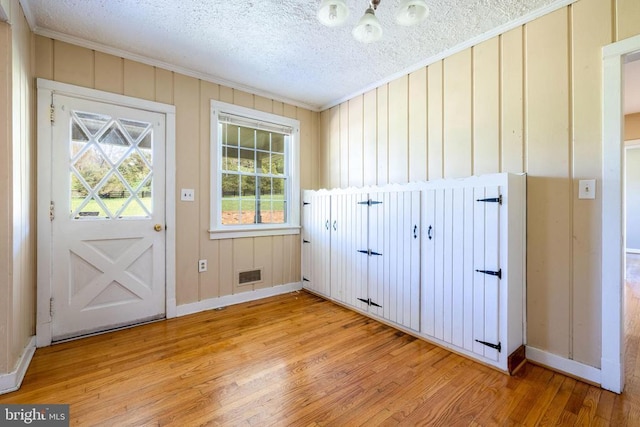 407 Kite Hollow Rd, Stanley, VA 22851 - doorway featuring crown molding, light wood-type flooring, baseboards, a textured ceiling, and a chandelier