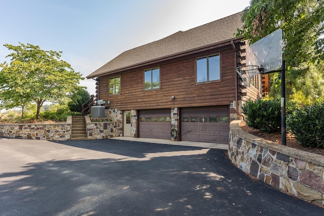 1003 Natural Chimneys Rd, Mount Solon, VA 22843 - view of side of property with an attached garage, driveway, log exterior, and central AC