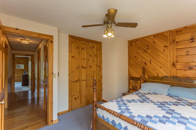 1003 Natural Chimneys Rd, Mount Solon, VA 22843 - bedroom with a ceiling fan, a closet, a textured ceiling, baseboards, and wooden walls