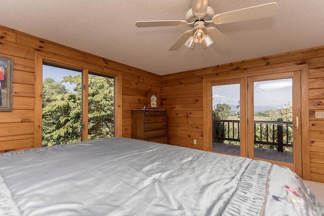 1003 Natural Chimneys Rd, Mount Solon, VA 22843 - bedroom with a textured ceiling, wooden walls, access to exterior, and ceiling fan