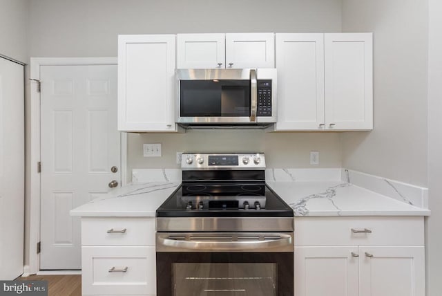 5907 Cambridge Dr, Fredericksburg, VA 22407 - kitchen with stainless steel appliances, white cabinets, light stone counters, and wood finished floors