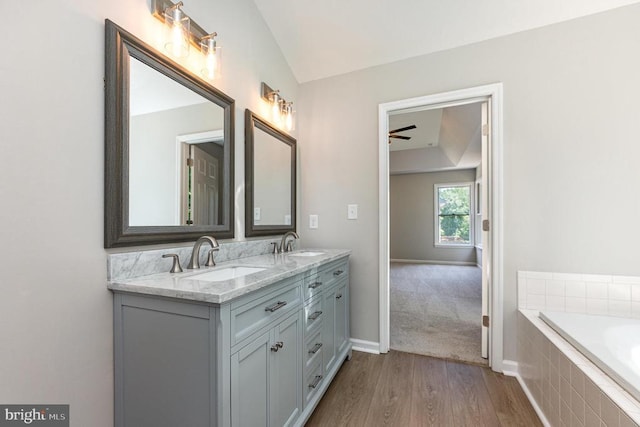 5907 Cambridge Dr, Fredericksburg, VA 22407 - bathroom featuring double vanity, wood finished floors, a relaxing tiled tub, baseboards, and a ceiling fan