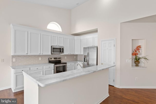 5910 Carnifex Ferry Rd W, Fredericksburg, VA 22407 - kitchen featuring appliances with stainless steel finishes, white cabinets, dark wood-type flooring, backsplash, and baseboards