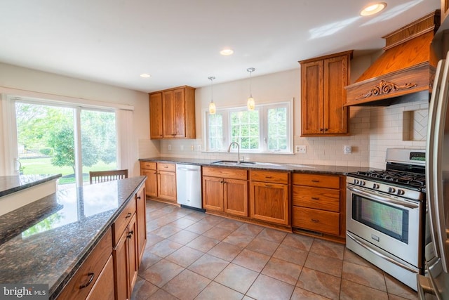 kitchen featuring appliances with stainless steel finishes, a sink, brown cabinetry, tasteful backsplash, and recessed lighting