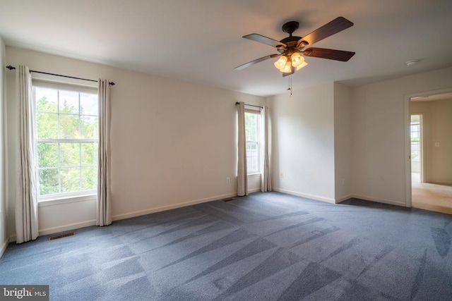 carpeted empty room featuring ceiling fan and baseboards