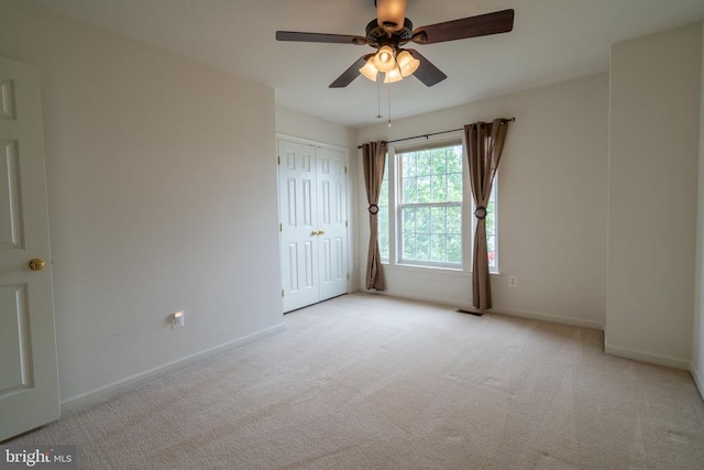 spare room featuring carpet floors, baseboards, and a ceiling fan
