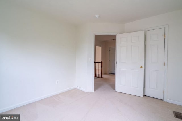 unfurnished bedroom with light carpet and baseboards