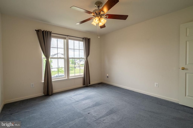 carpeted spare room with baseboards and ceiling fan